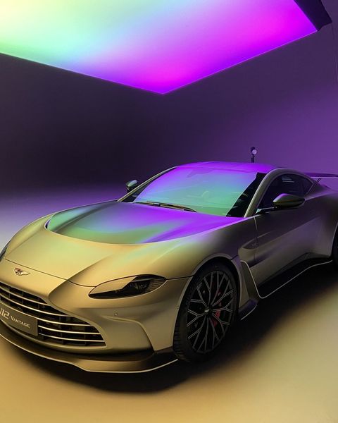 An Aston Martin V12 Vantage under coloured studio light